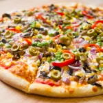 A vibrant veggie pizza generously topped with black olives — garden-fresh flavor on every slice at WiseGuys Pizza.