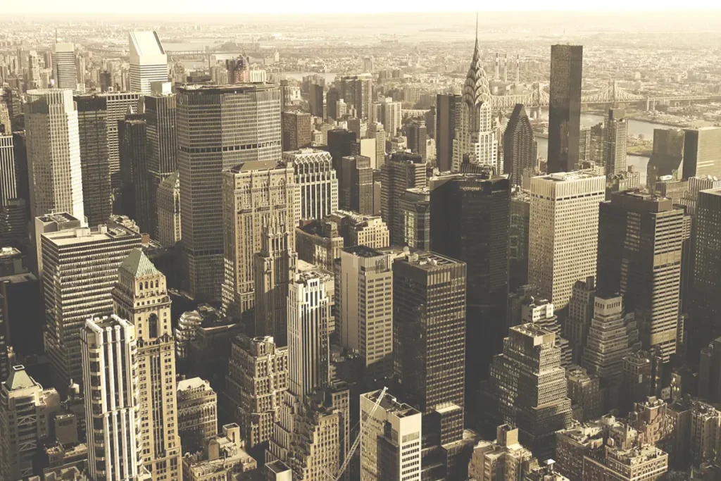 A nostalgic glimpse at a vintage New York City skyline reflected over a river—capturing the historic charm that inspires WiseGuys Pizza.