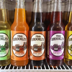 Bottles of Olde Brooklyn soda featuring the Bridge and skyline. Flavors include Flatbush Orange Soda, Williamsburg Root
