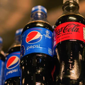 Bottles of Pepsi and Coca-Cola soda drinks on a dark background, showcasing the refreshing beverage options at Wise Guys